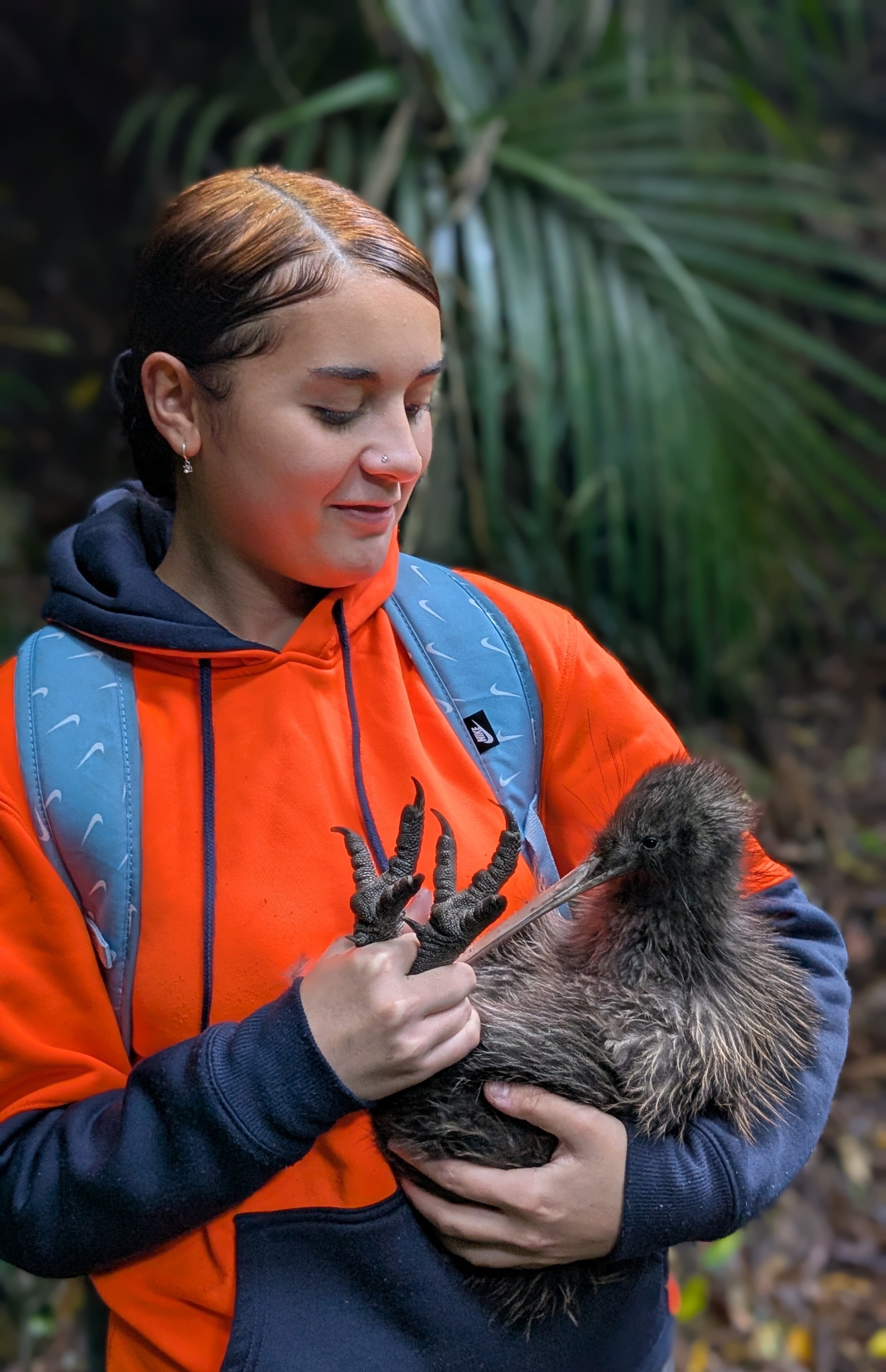 Young ranger in hi-vis holding a kiwi